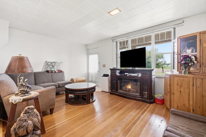 Living space featuring wood-finish flooring, white walls, and a recessed ceiling light