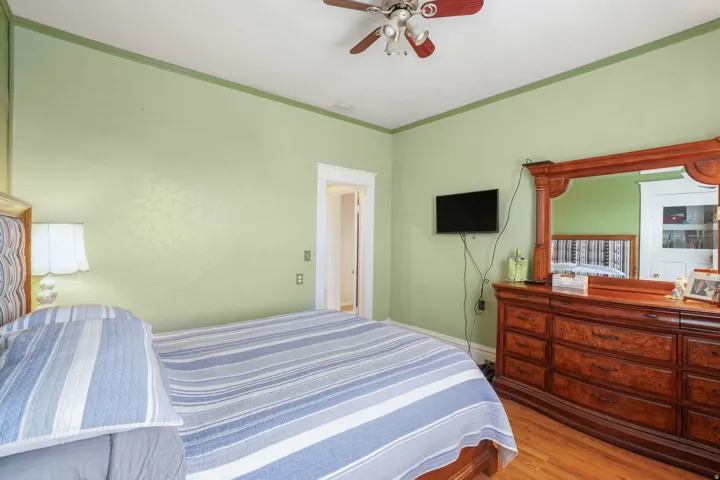 Bedroom featuring wood-finish flooring and a ceiling fan with integrated lighting