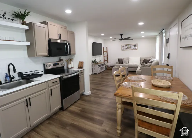 Kitchen with stainless steel appliances, open floor plan, open shelves, dark wood-style flooring, and ceiling fan