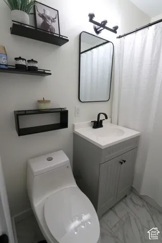 Bathroom featuring vanity, light marble finish floors, and a shower with shower curtain