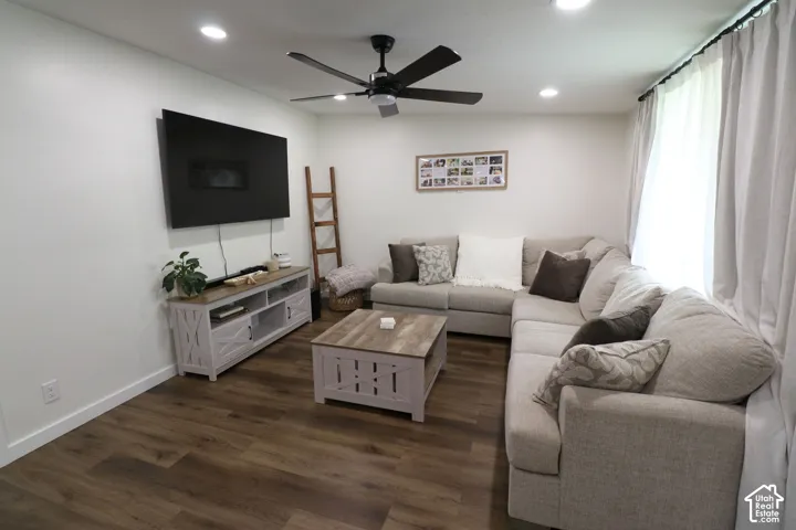 Living room with a ceiling fan, dark wood-style flooring, and recessed lighting