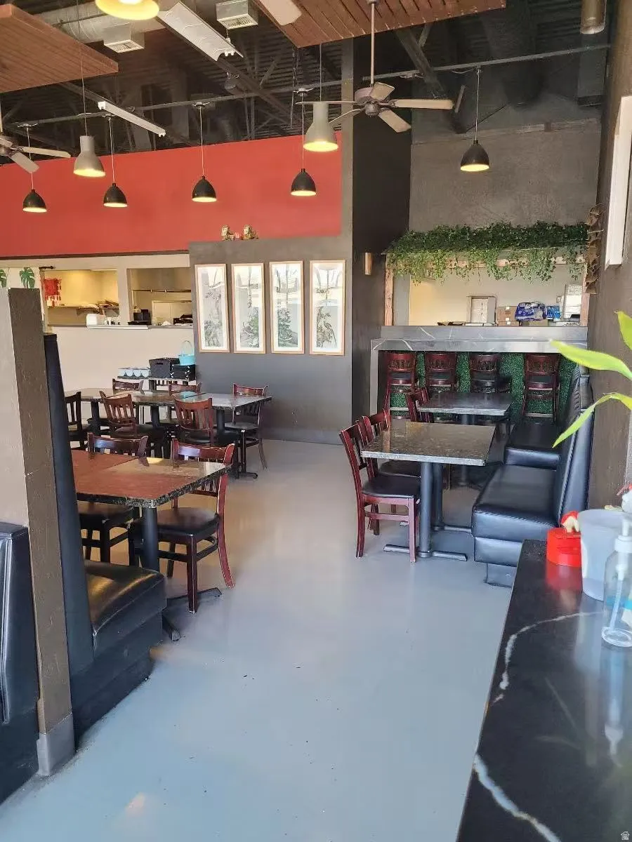 Dining space with finished concrete floors, a high ceiling, and ceiling fan