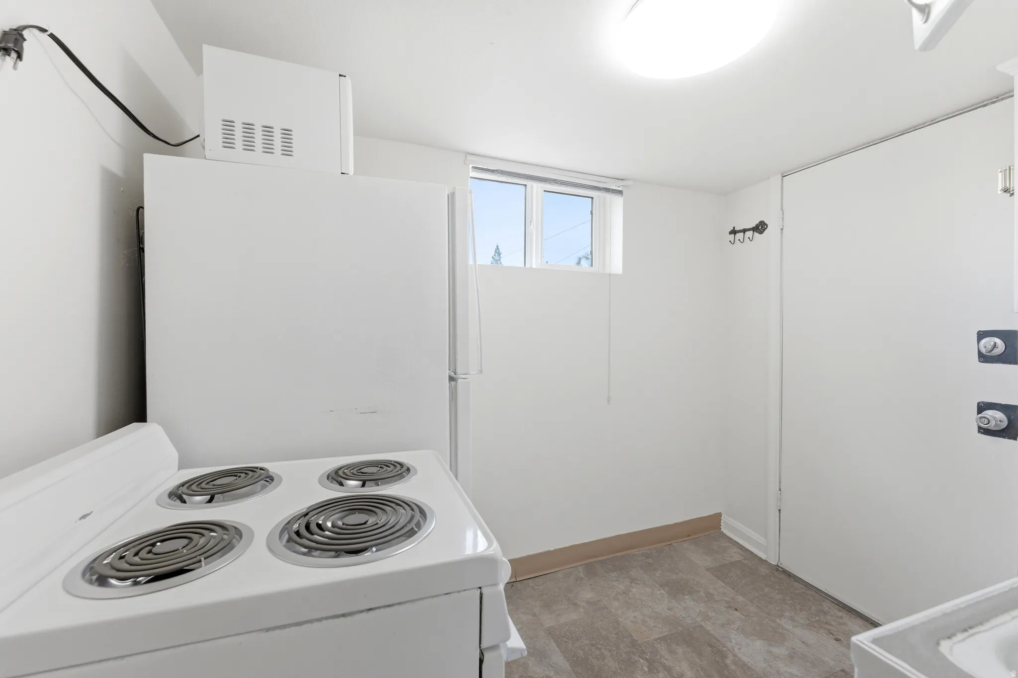 Kitchen featuring white appliances and white cabinetry