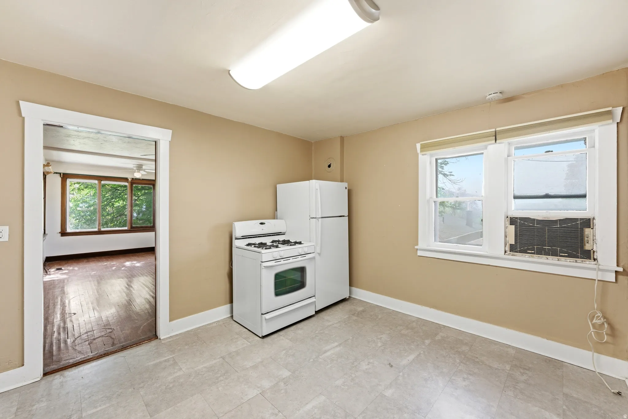 Kitchen with white appliances and cooling unit