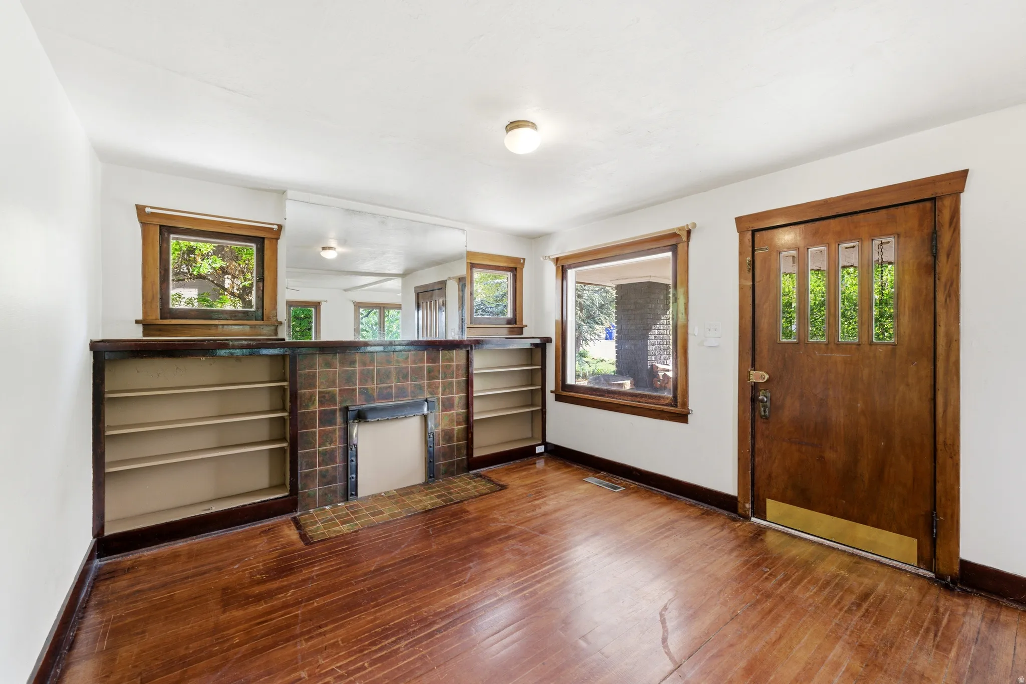 Entryway with dark wood-style floors, healthy amount of natural light, and a tile fireplace