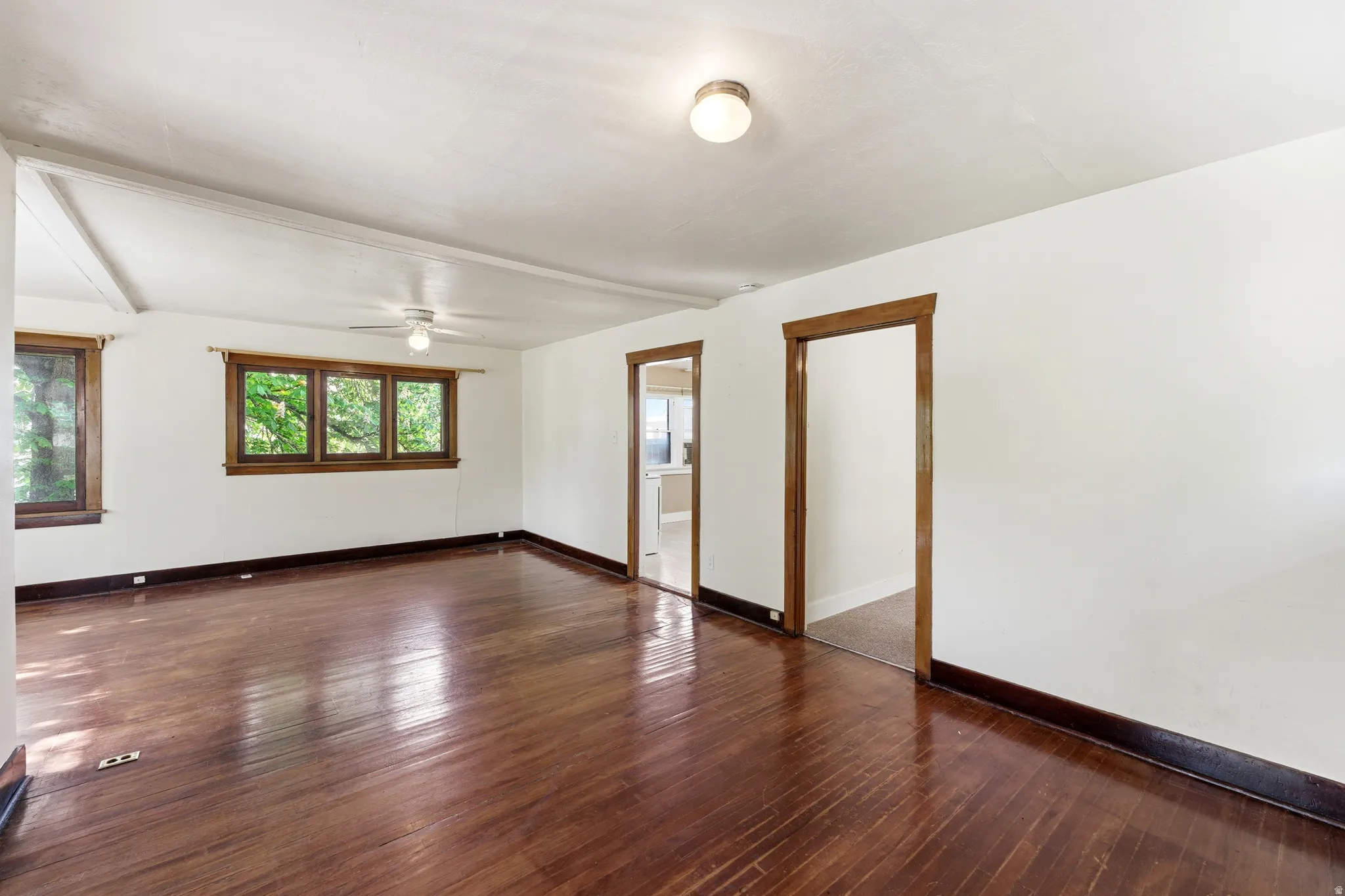 Empty room featuring dark wood-style flooring and ceiling fan