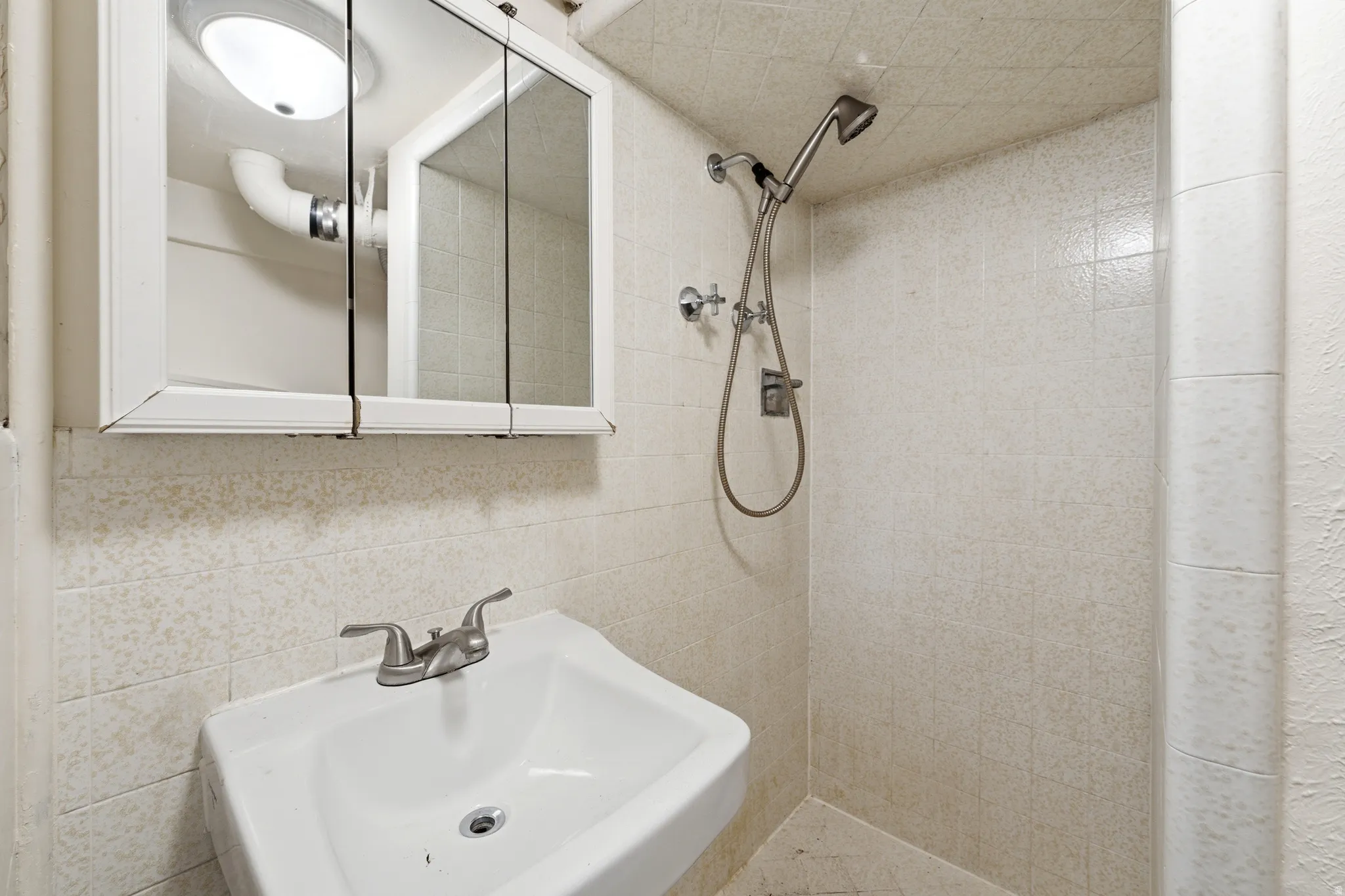 Bathroom with a shower stall and tile walls
