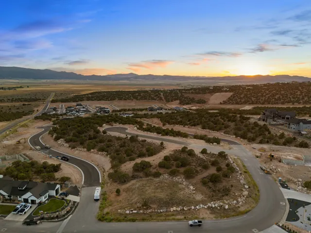 Expansive undeveloped land featuring paved roads and distant mountain scenery