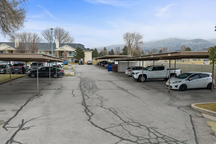 Covered parking lot featuring a residential view and a mountain view