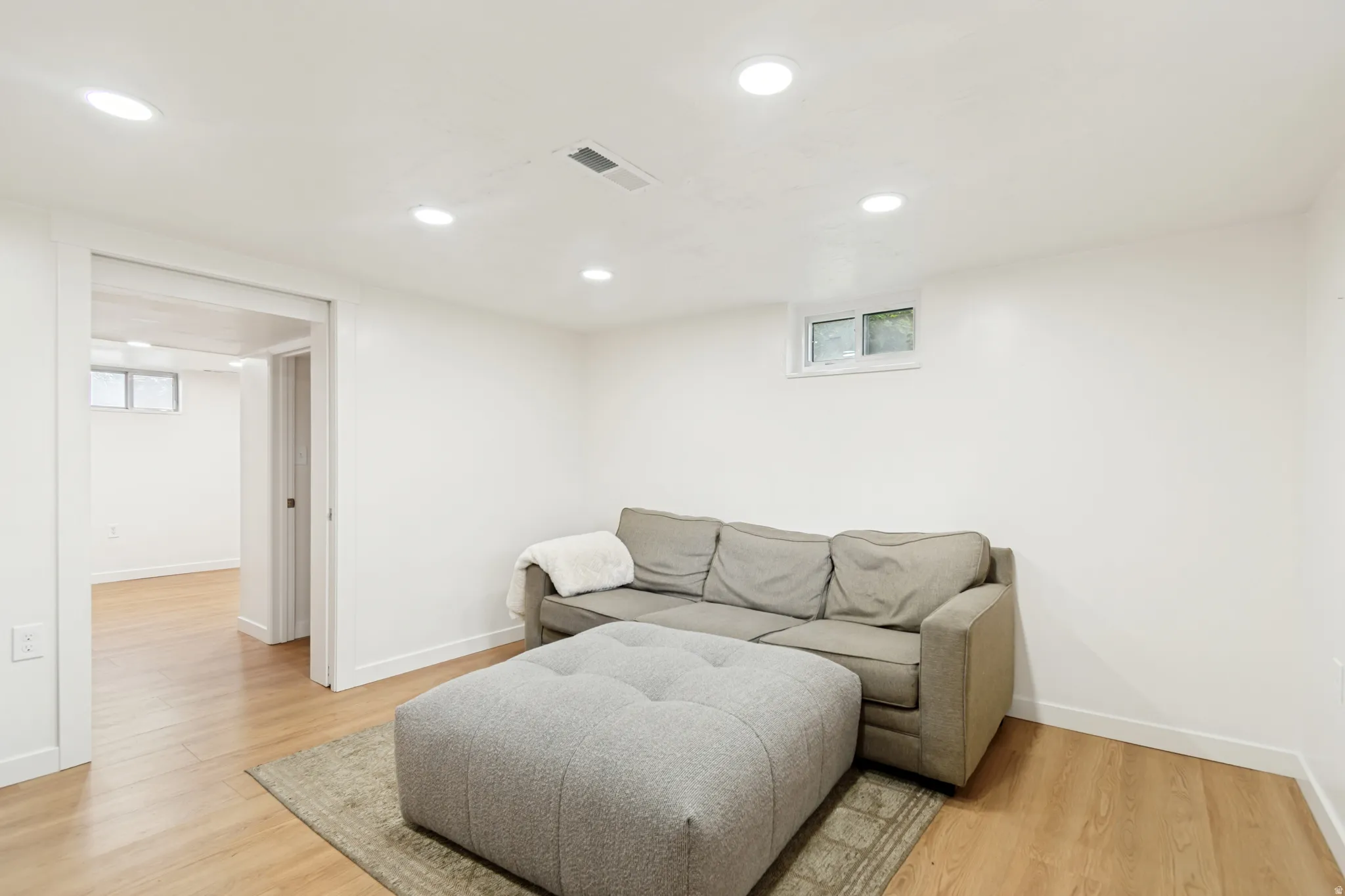 Living area with light wood-type flooring, recessed lighting, and plenty of natural light
