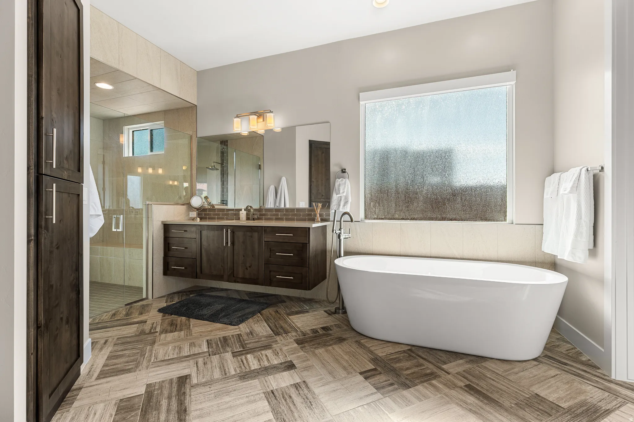 Bathroom with vanity, a freestanding bath, a stall shower, and recessed lighting
