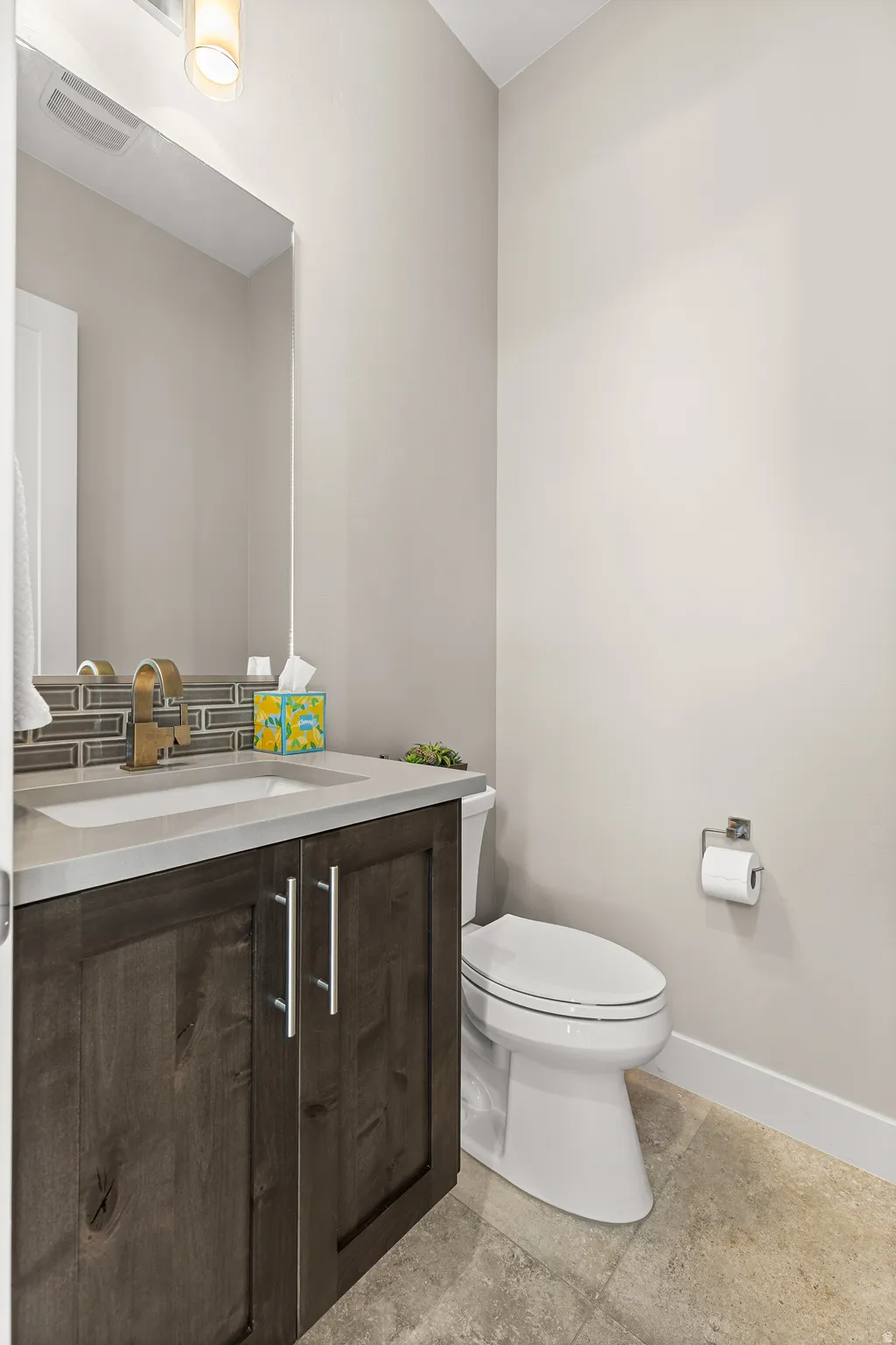 Half bathroom with vanity and baseboards