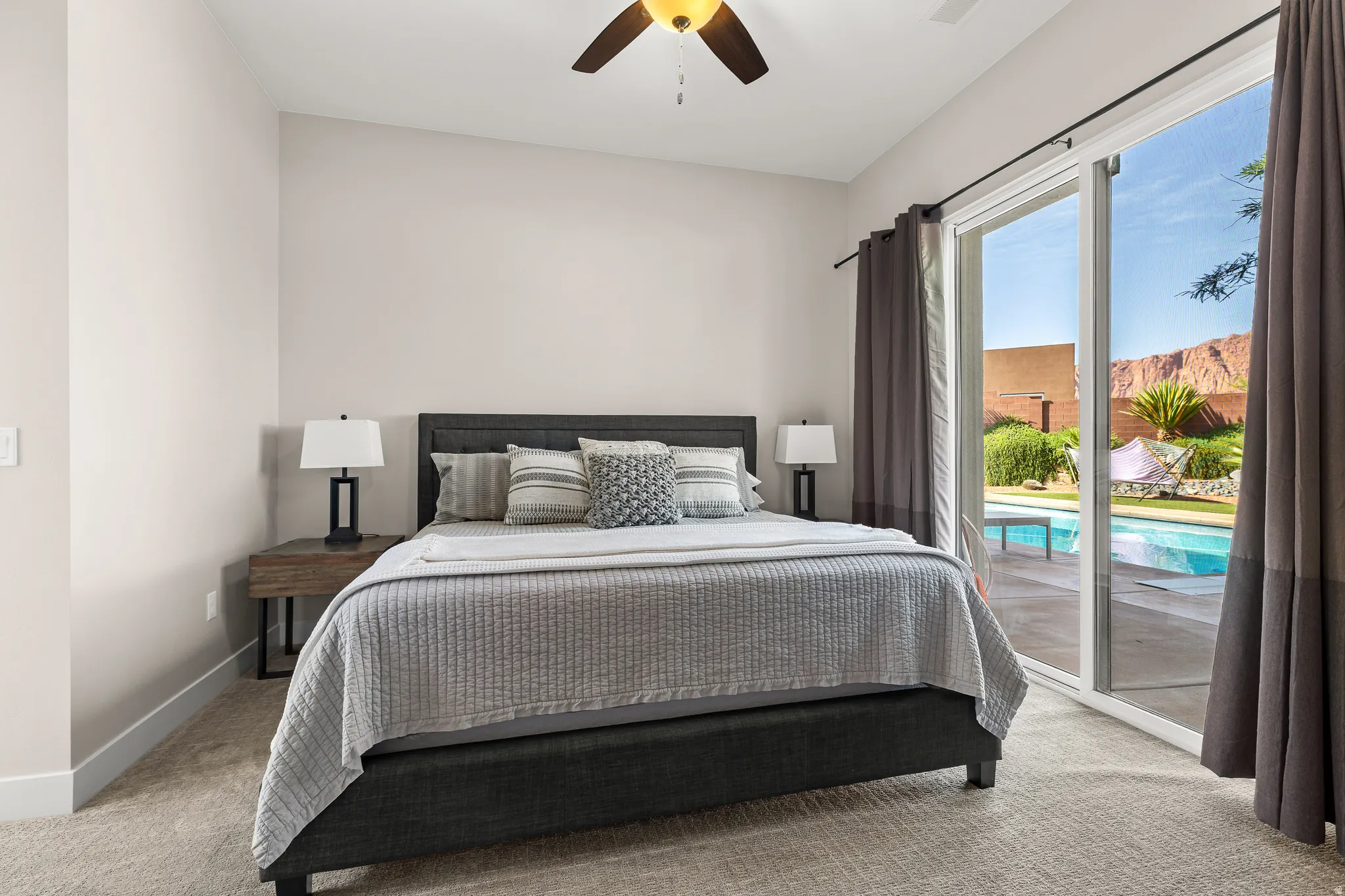 Carpeted bedroom with access to exterior and ceiling fan