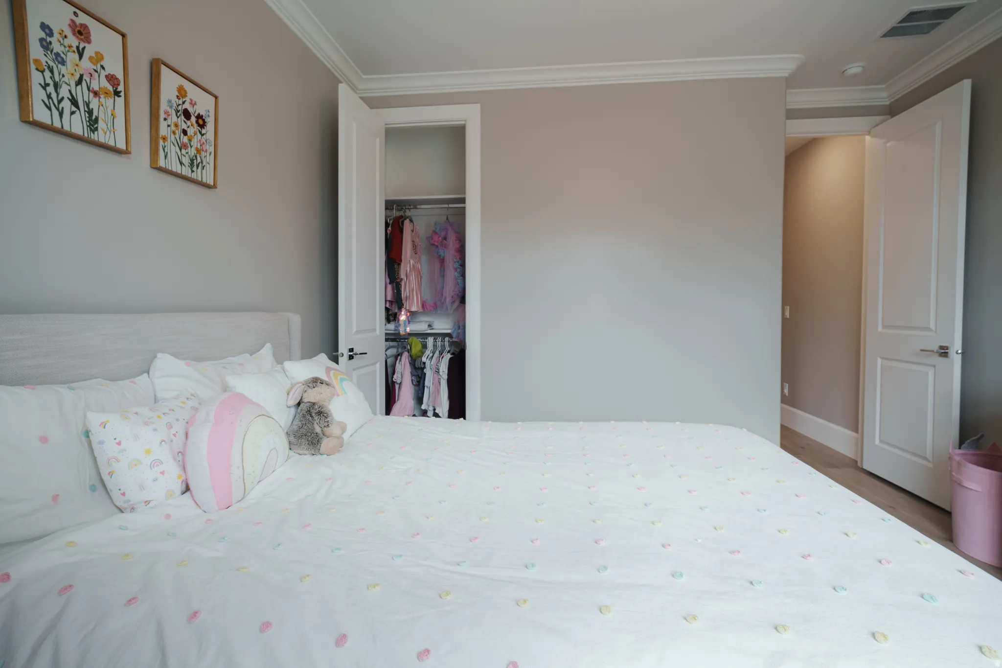 Bedroom with crown molding, a closet, and light wood-type flooring