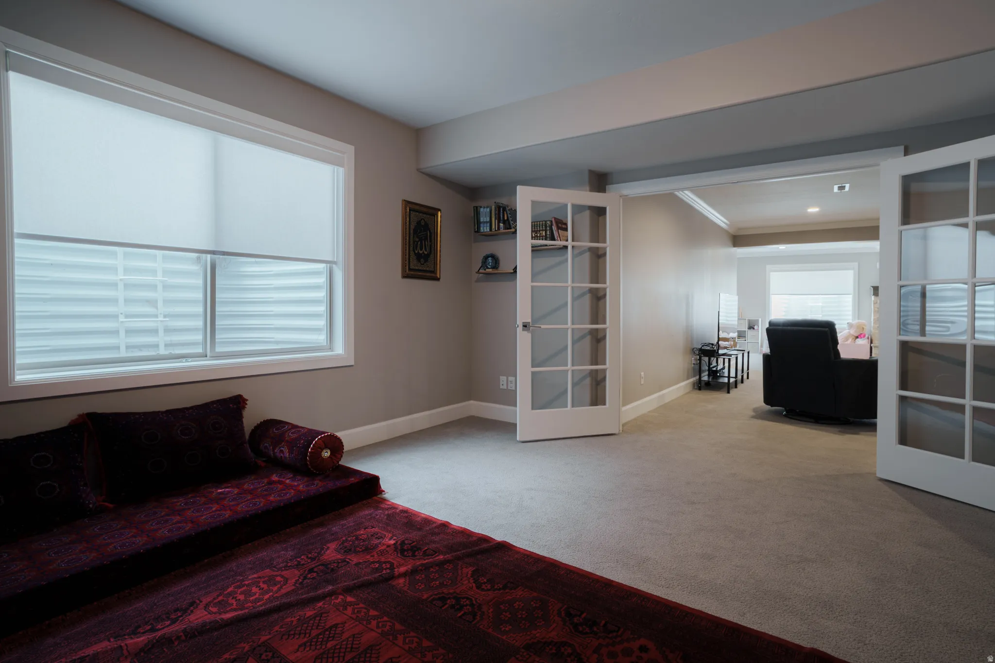 Living area with french doors, light carpet, and crown molding