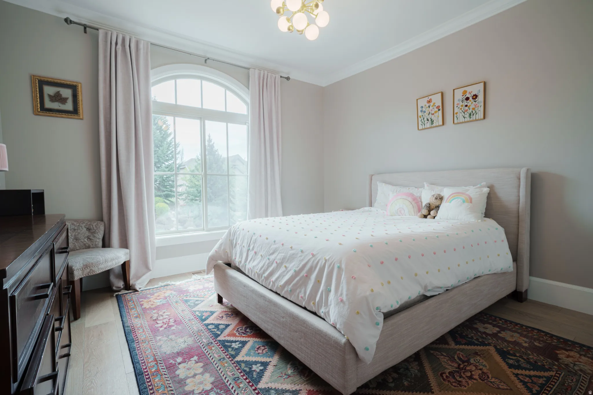 Bedroom featuring light wood-type flooring, ornamental molding, and suspended lighting