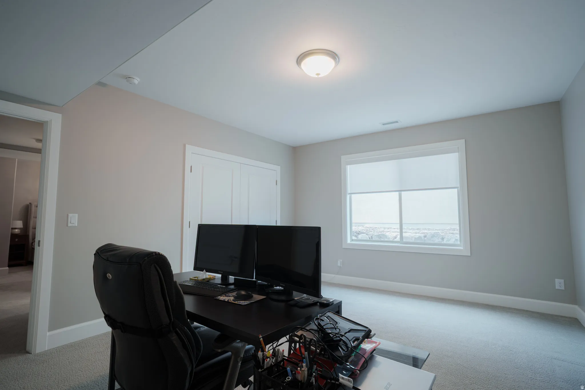 Office space with light carpet and baseboards