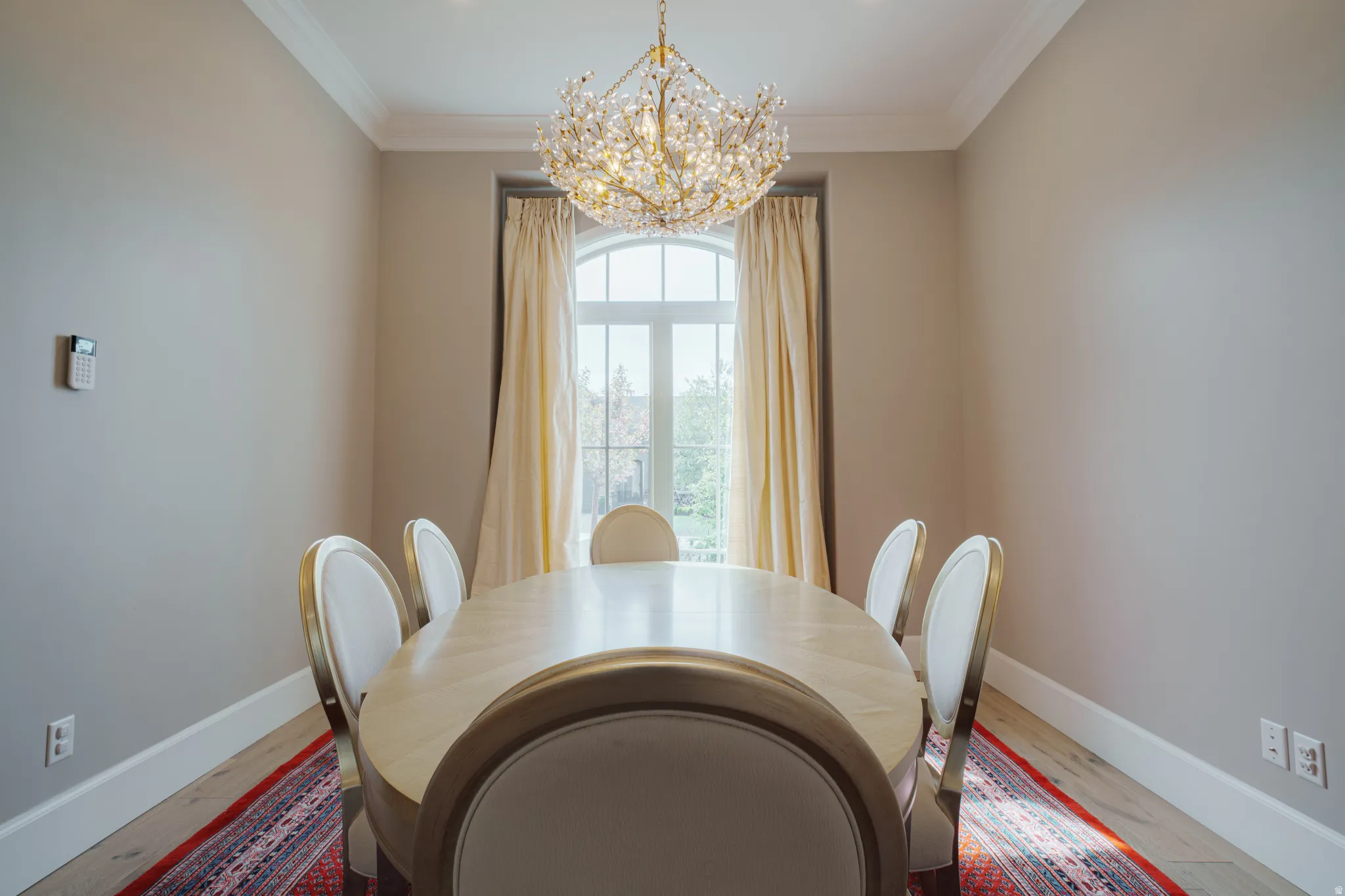 Dining space featuring suspended lighting, wood finished floors, and crown molding