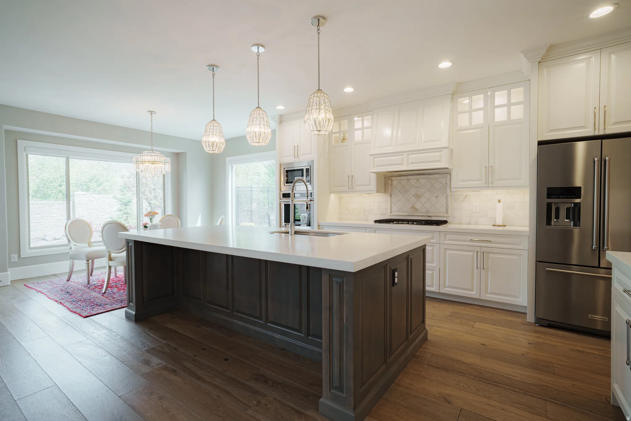 Dual tone kitchen featuring glass fronted cabinets, dual tone cabinetry, stainless steel appliances, dark wood-type flooring, and backsplash