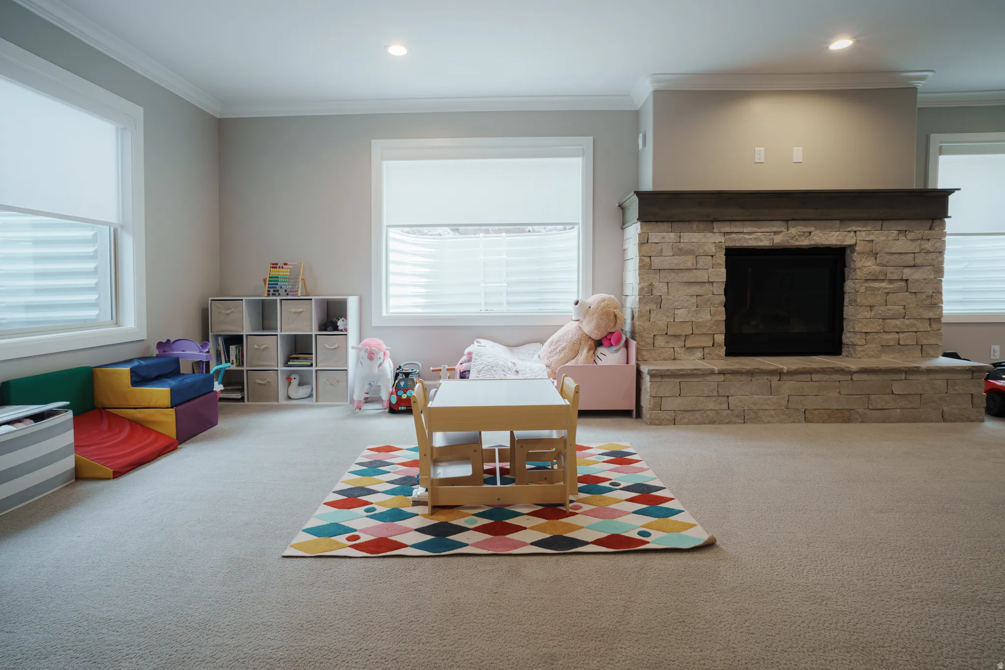 Recreation room featuring crown molding, a fireplace, carpet flooring, and recessed lighting