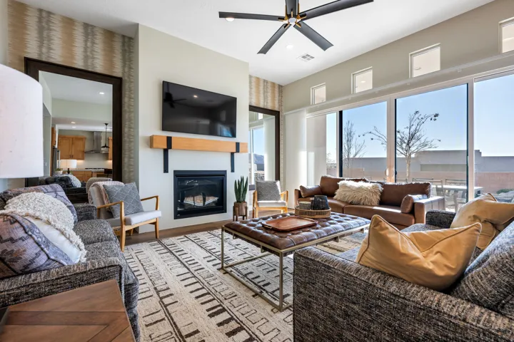 Living area featuring ceiling fan, a glass covered fireplace, light wood-style flooring, and recessed lighting