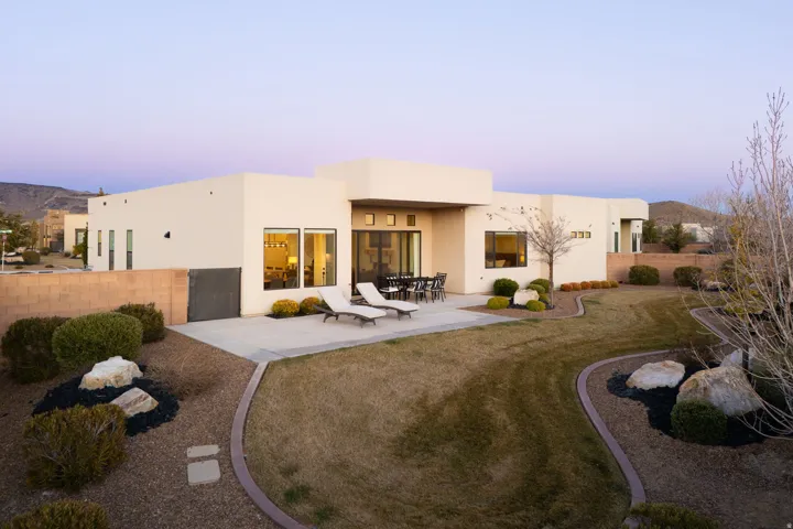 Back of house at dusk with a fenced backyard, a patio, and stucco siding