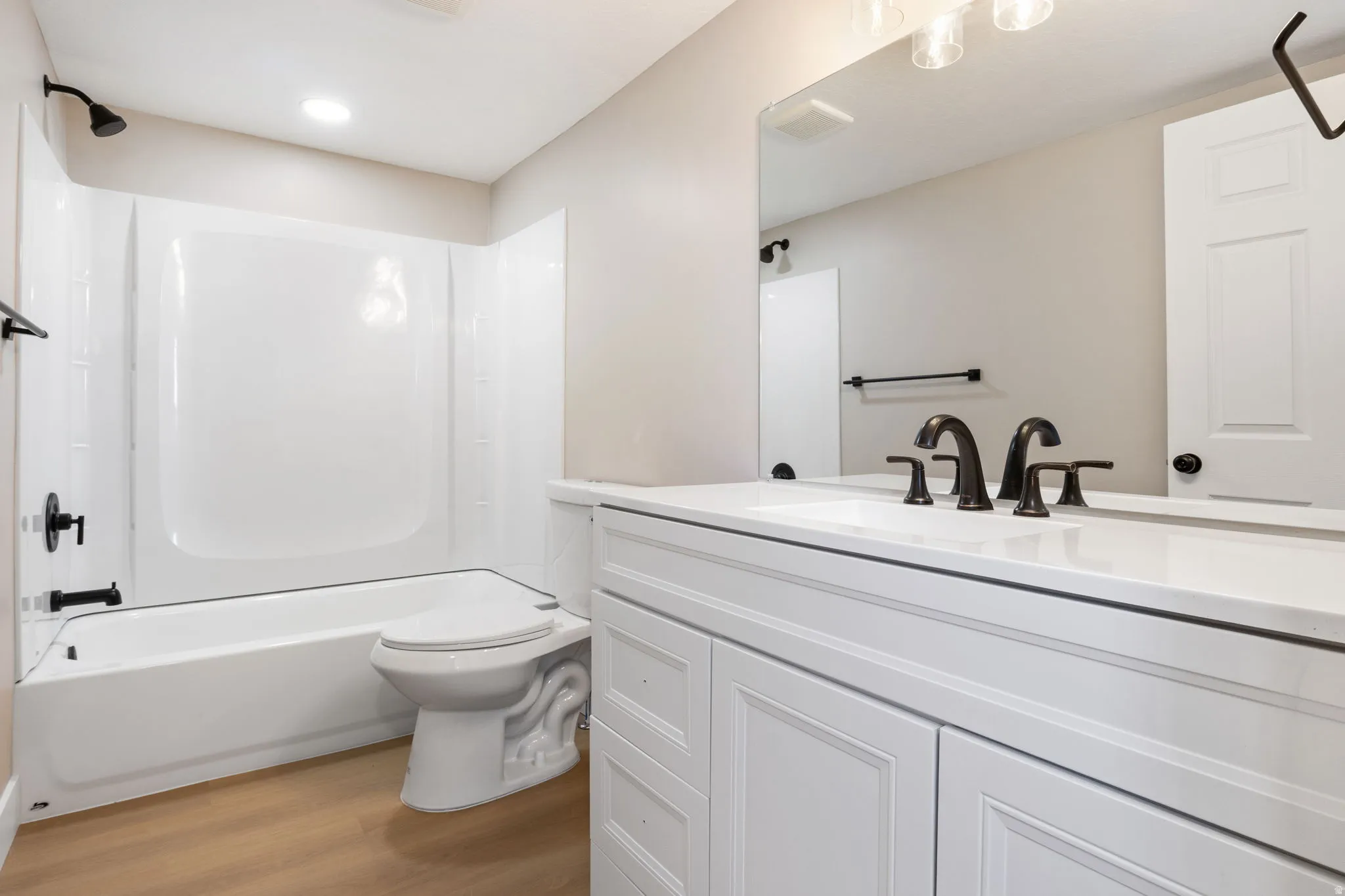 Bathroom featuring vanity, light wood-type flooring, and washtub / shower combination