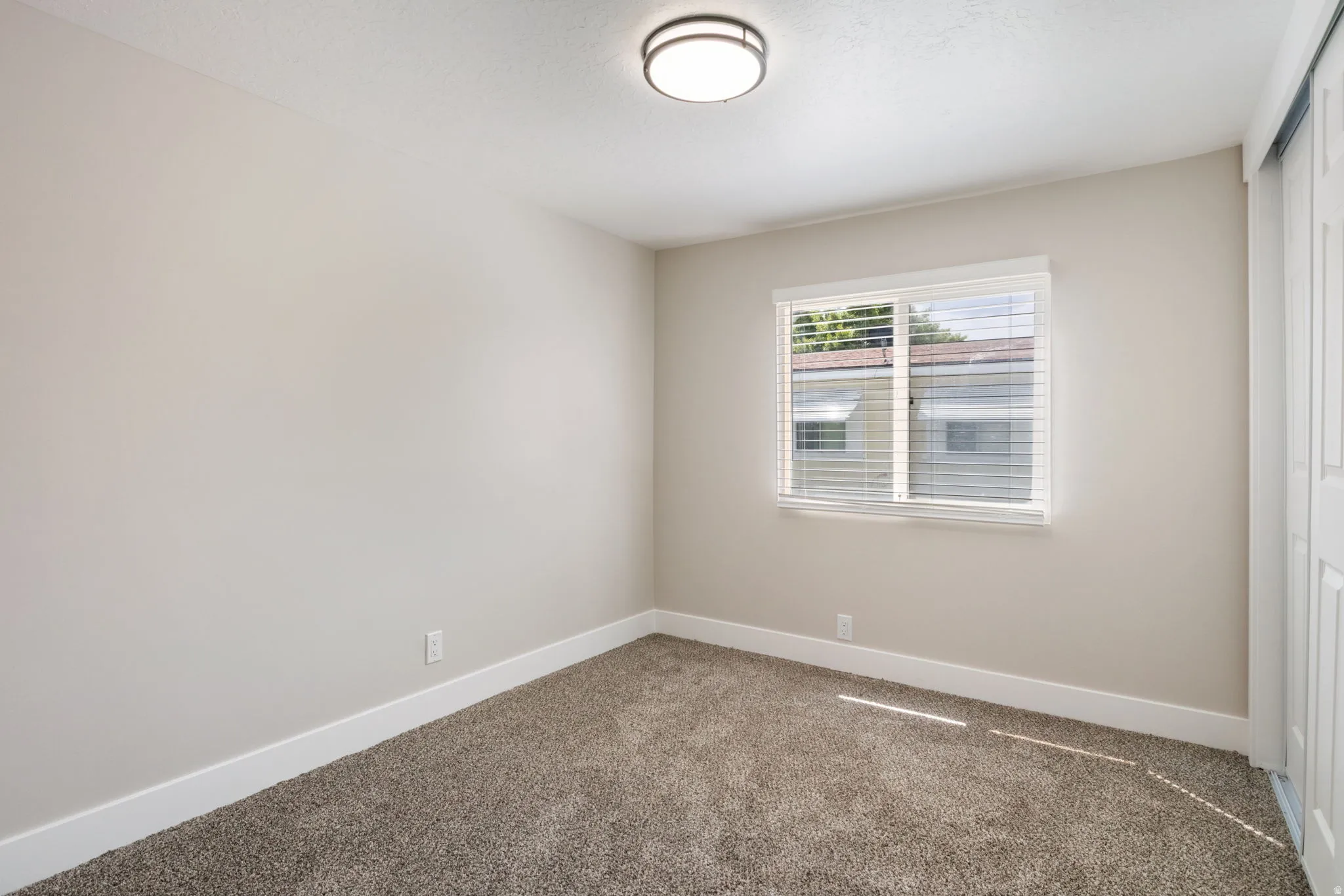 Empty room with baseboards and carpet