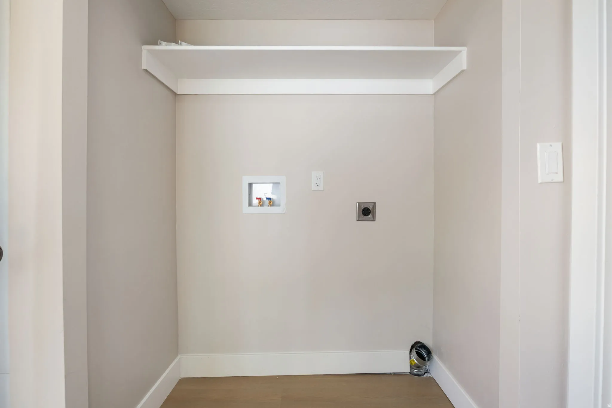 Laundry area featuring hookup for an electric dryer, wood finished floors, and washer hookup