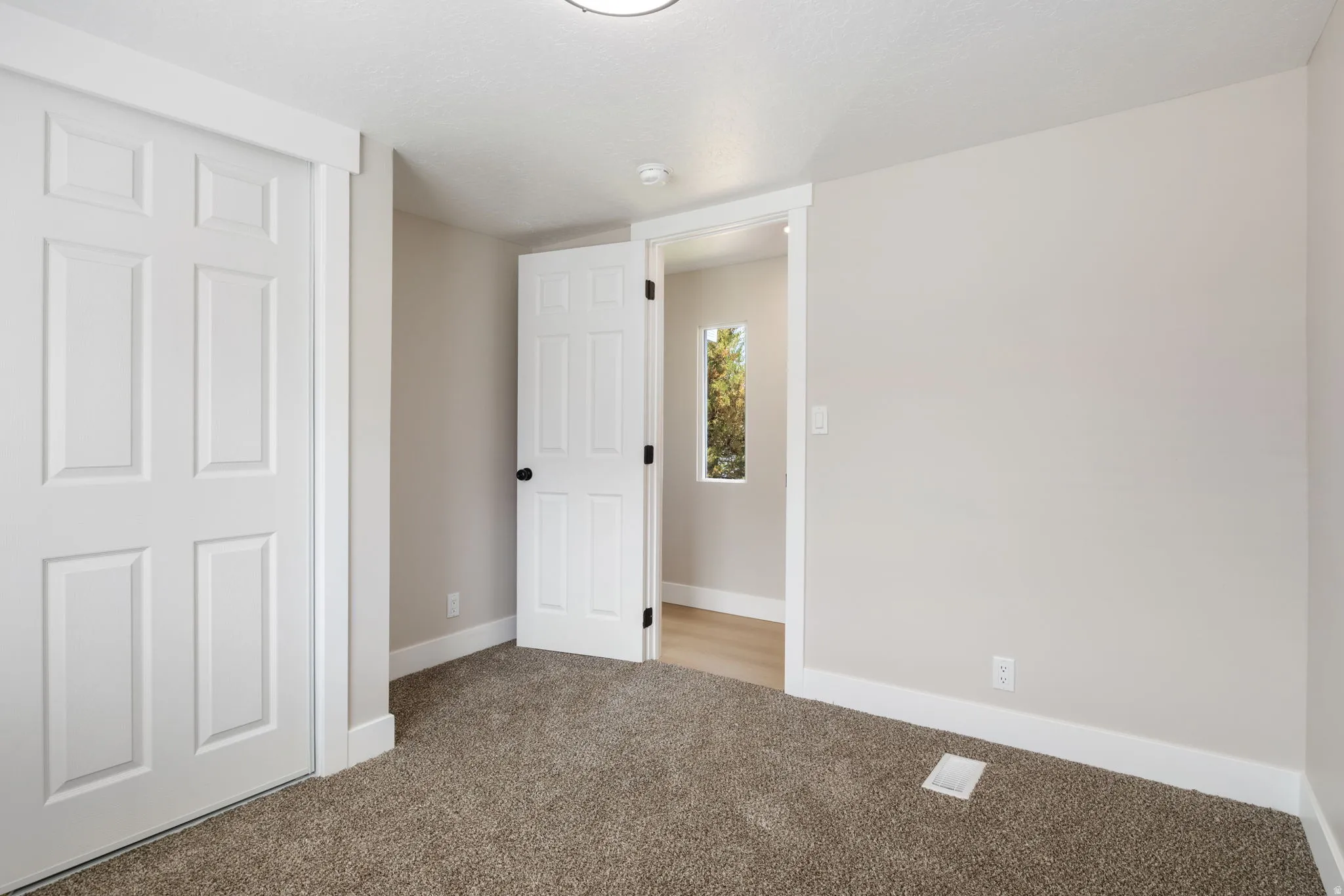 Unfurnished bedroom featuring baseboards and light colored carpet