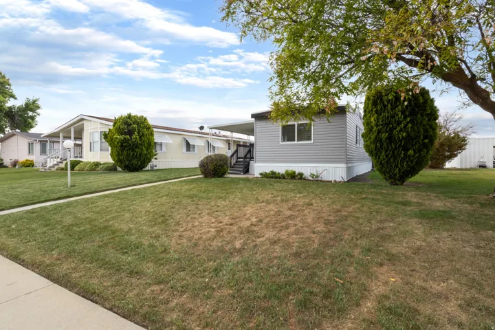 Manufactured / mobile home with a front yard and covered porch