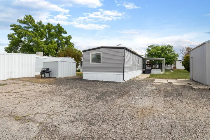 View of side of home with a storage unit