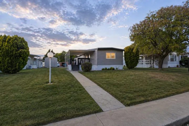 Manufactured / mobile home featuring a porch and a front yard
