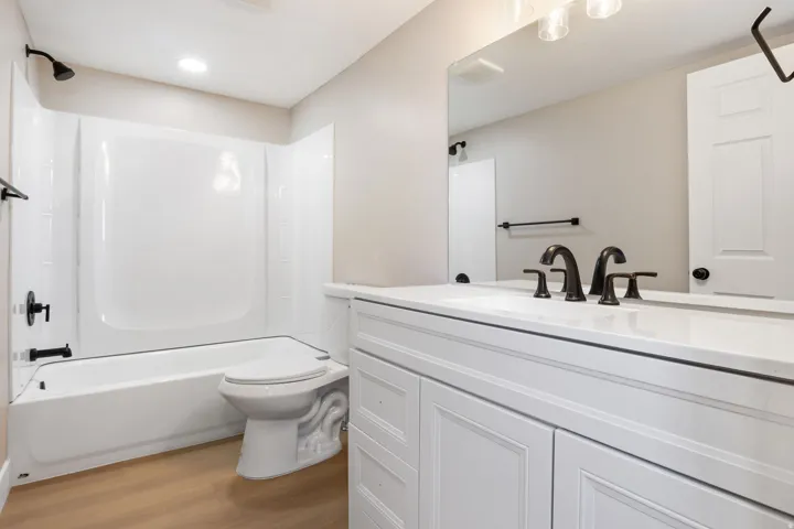 Bathroom featuring vanity, light wood-type flooring, and washtub / shower combination