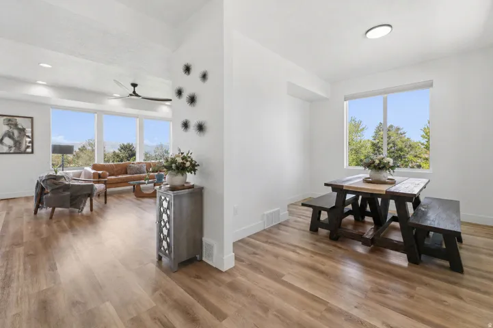 Dining space with wood finished floors, plenty of natural light, and a ceiling fan