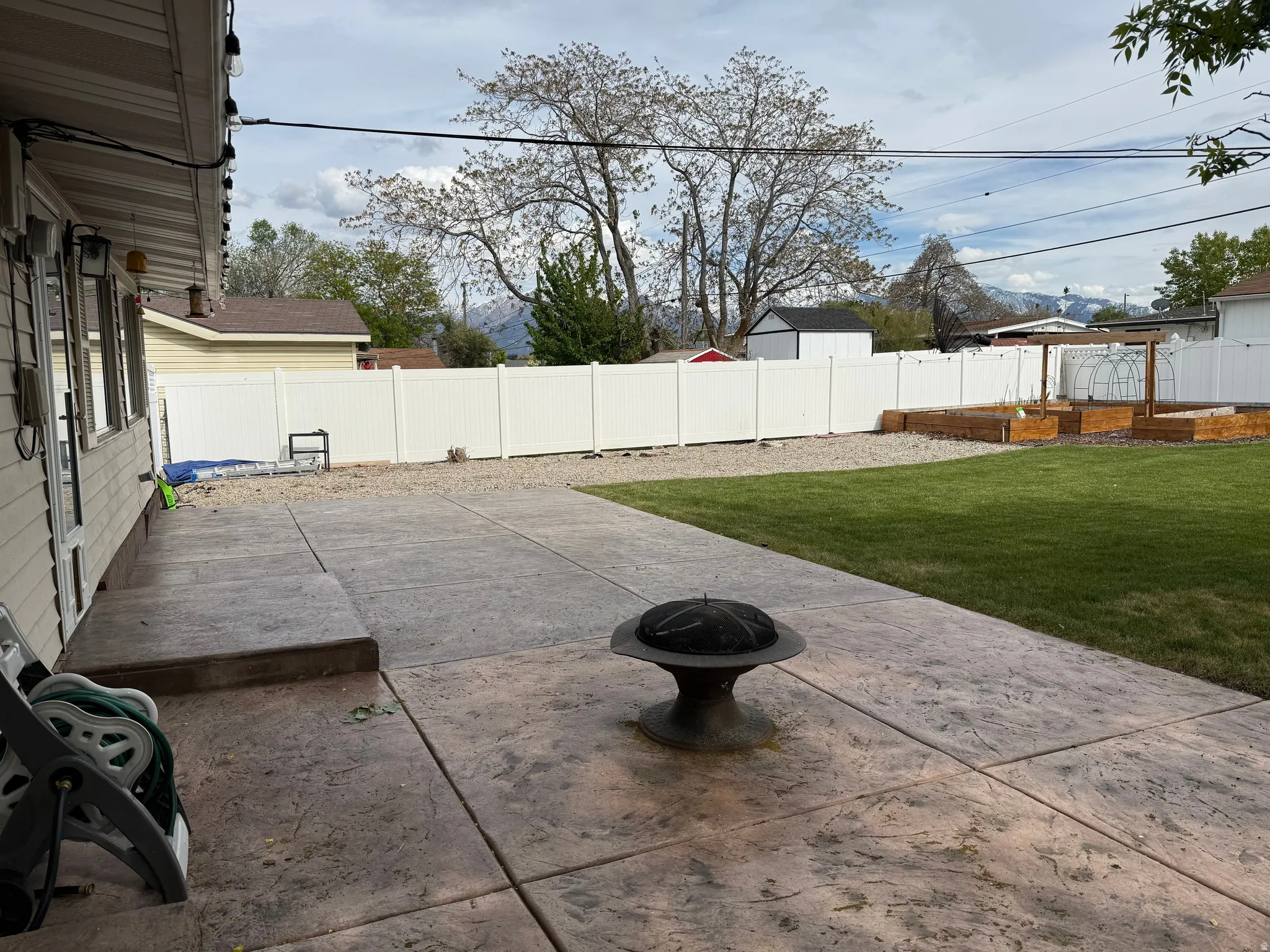 Fenced backyard featuring an outdoor fire pit and a patio area