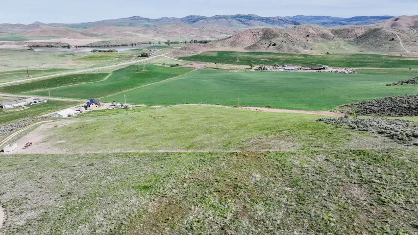 Expansive acreage featuring green fields and distant rolling hills