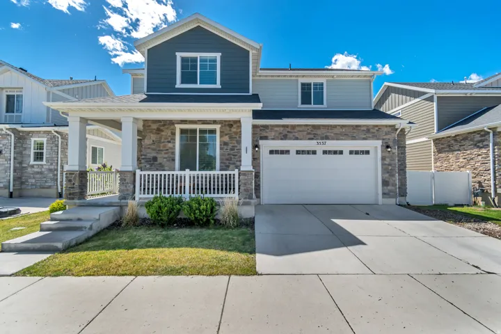 Craftsman inspired home featuring a porch, driveway, an attached garage, stone siding, and a front lawn