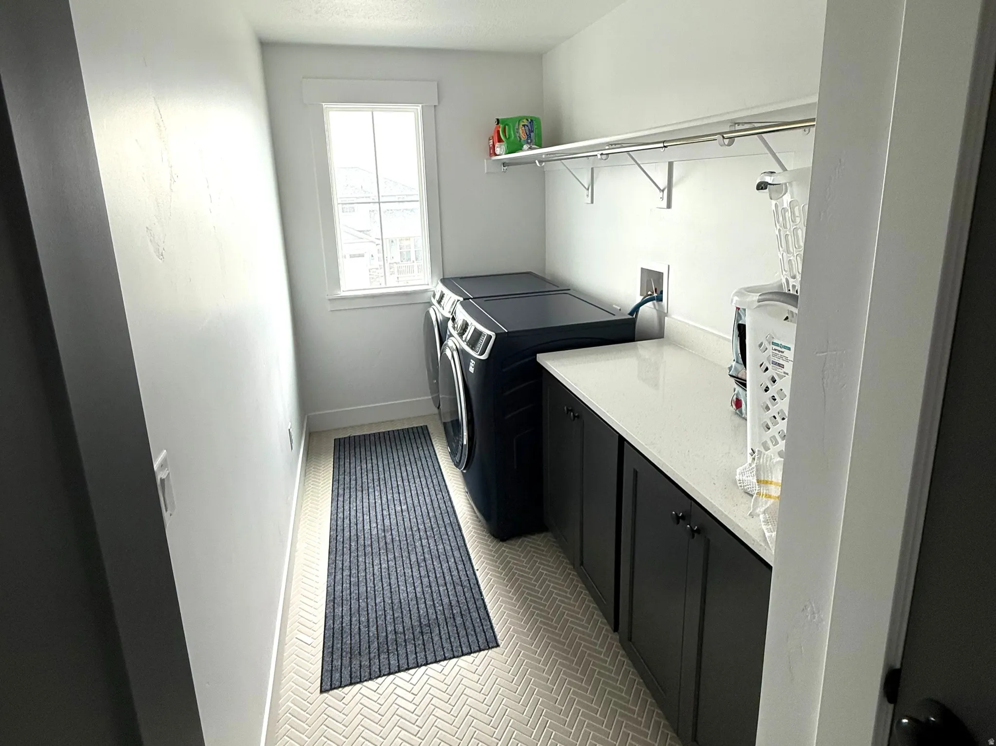 Laundry area featuring a textured ceiling, separate washer and dryer, and cabinet space