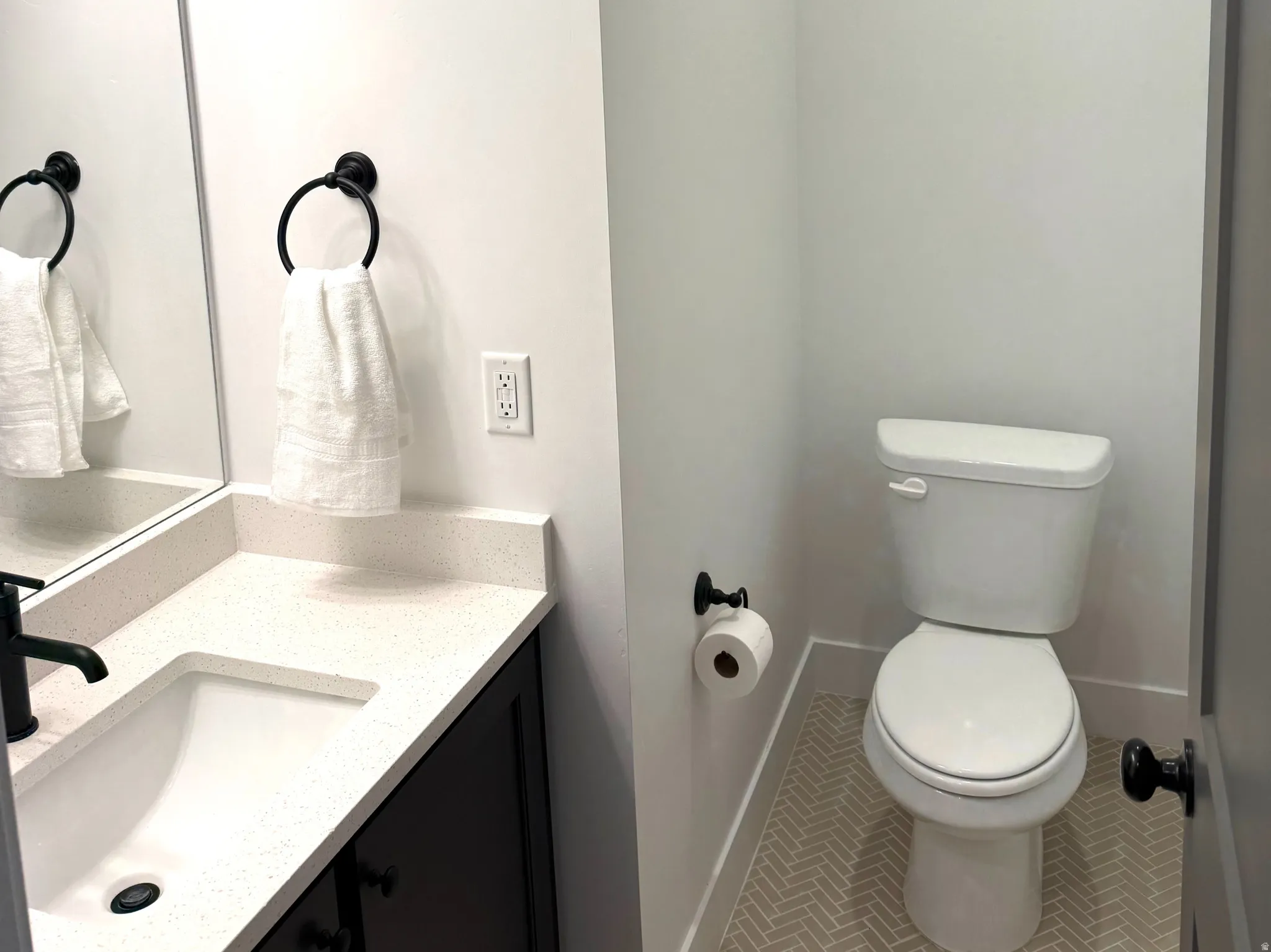 Half bath with vanity and tile patterned flooring