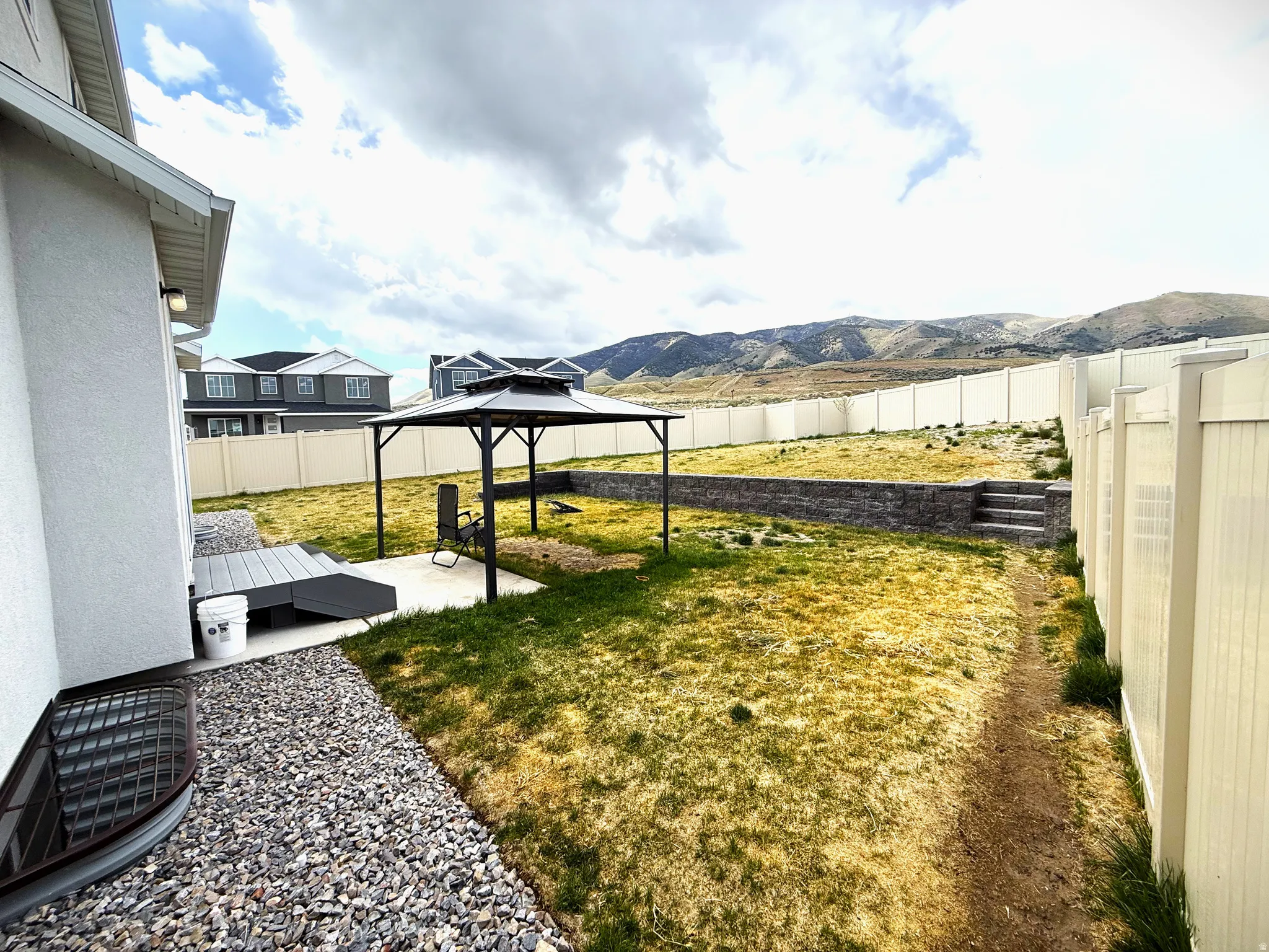 Fenced backyard with a patio, a gazebo, and a mountain view