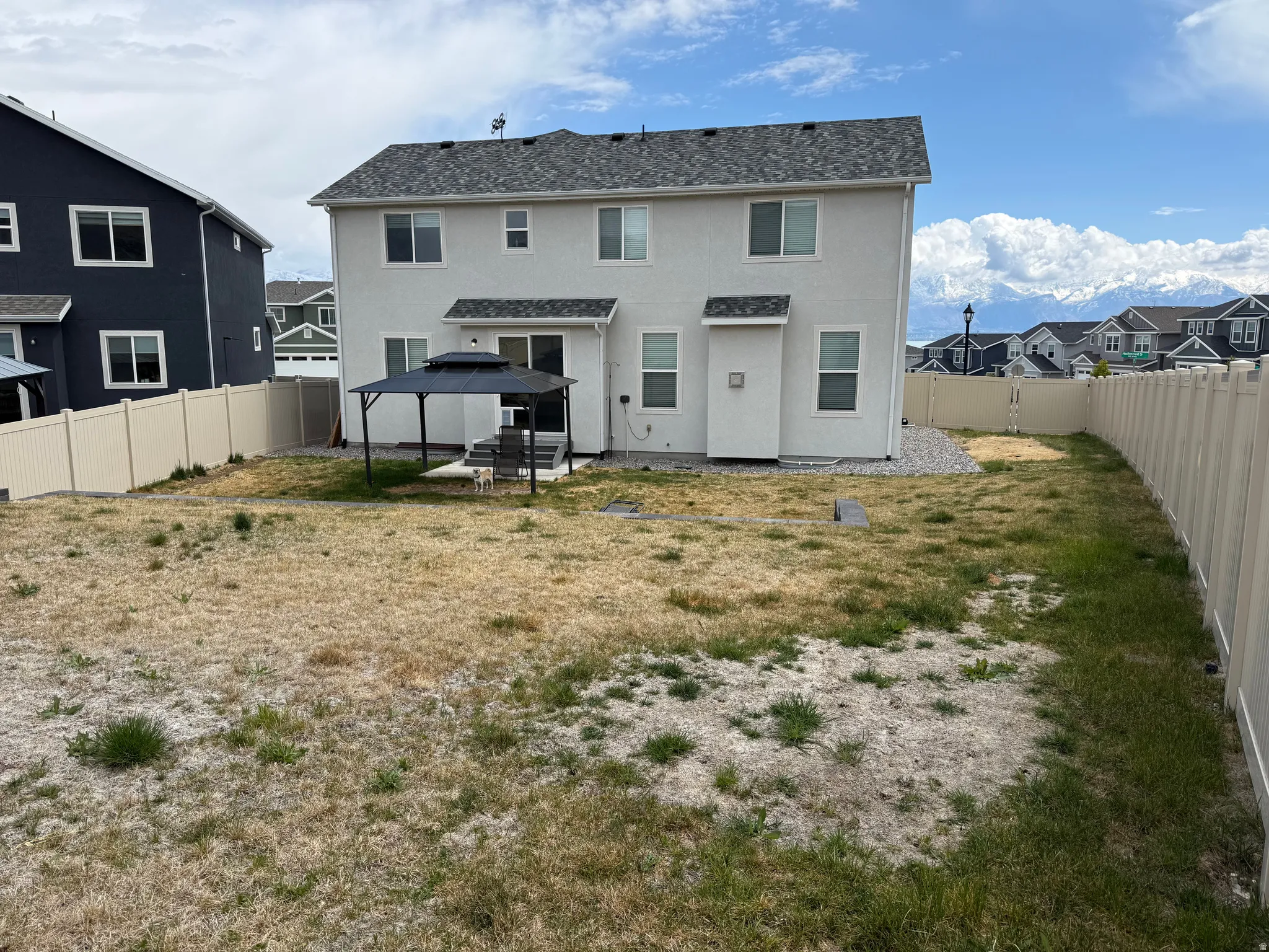 Back of house with a residential view, a fenced backyard, a patio, and stucco siding