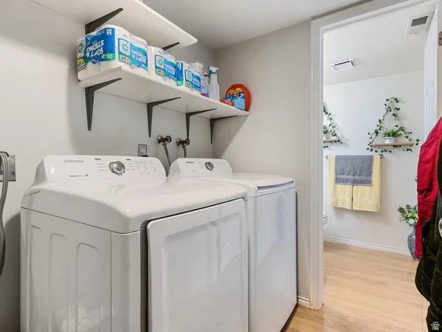 Laundry room featuring light wood-style floors and independent washer and dryer