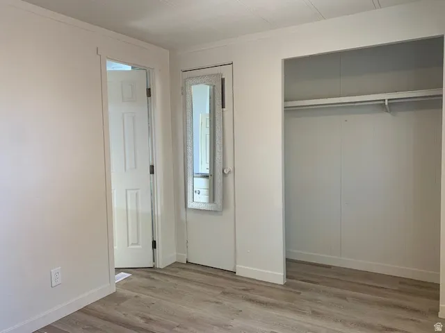 Unfurnished bedroom featuring light wood finished floors and ornamental molding