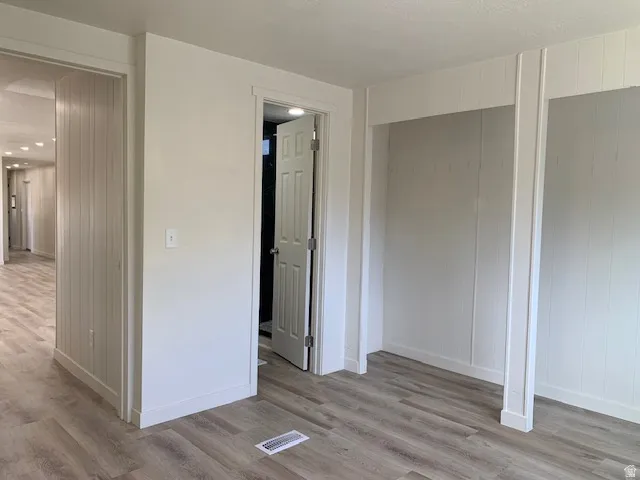 Unfurnished bedroom featuring light wood finished floors and baseboards