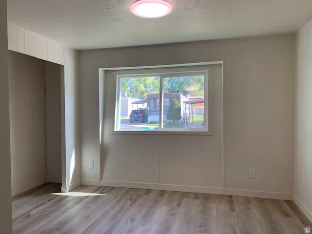 Primary Suite featuring a textured ceiling and light wood-style flooring
