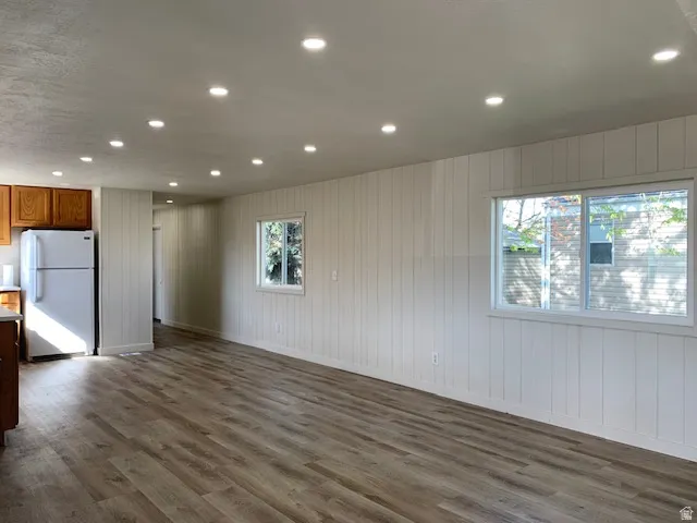 Unfurnished room featuring recessed lighting, dark wood-type flooring, and wood walls