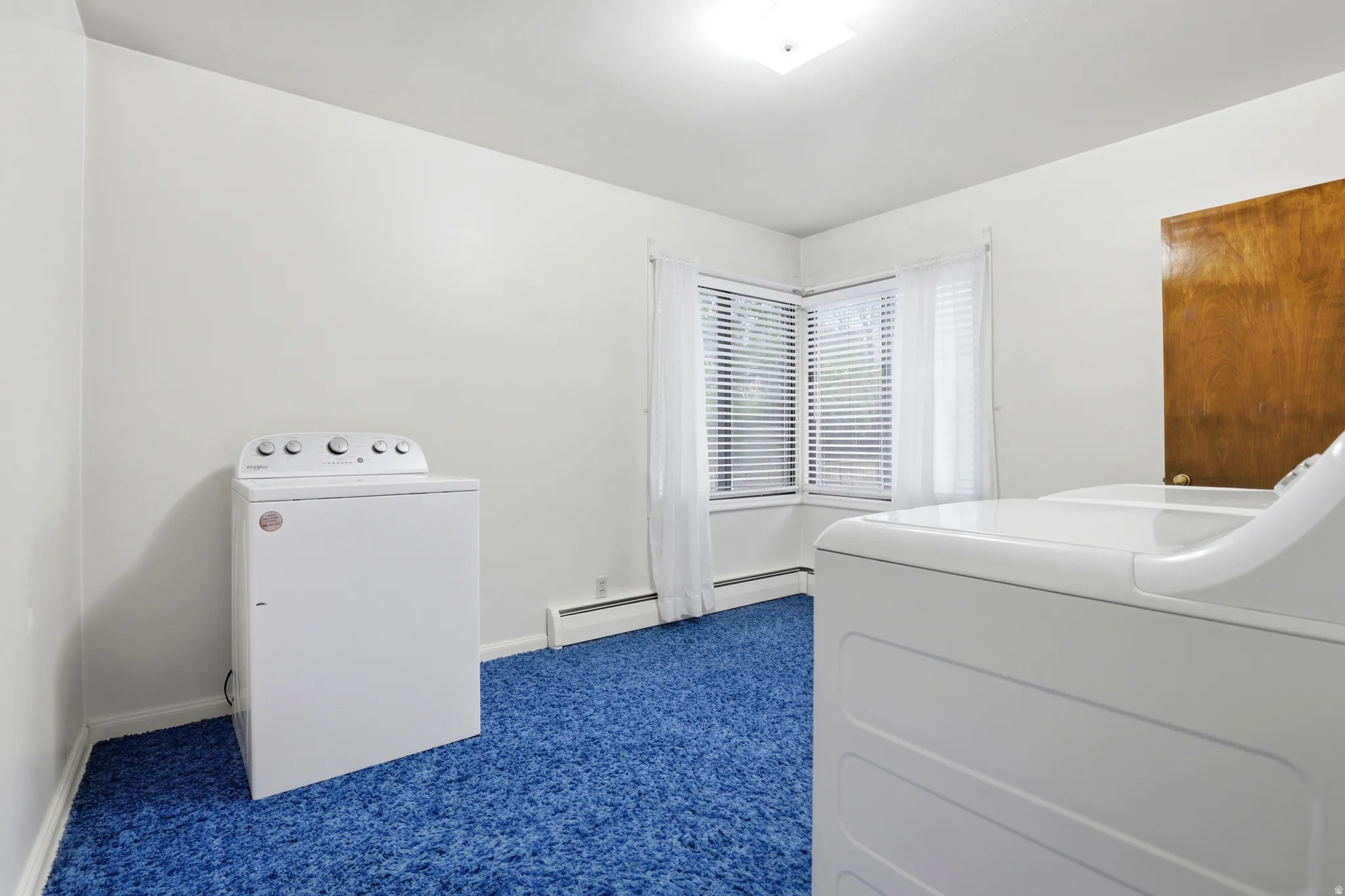 Bedroom with dark colored carpet and washing machine and clothes dryer