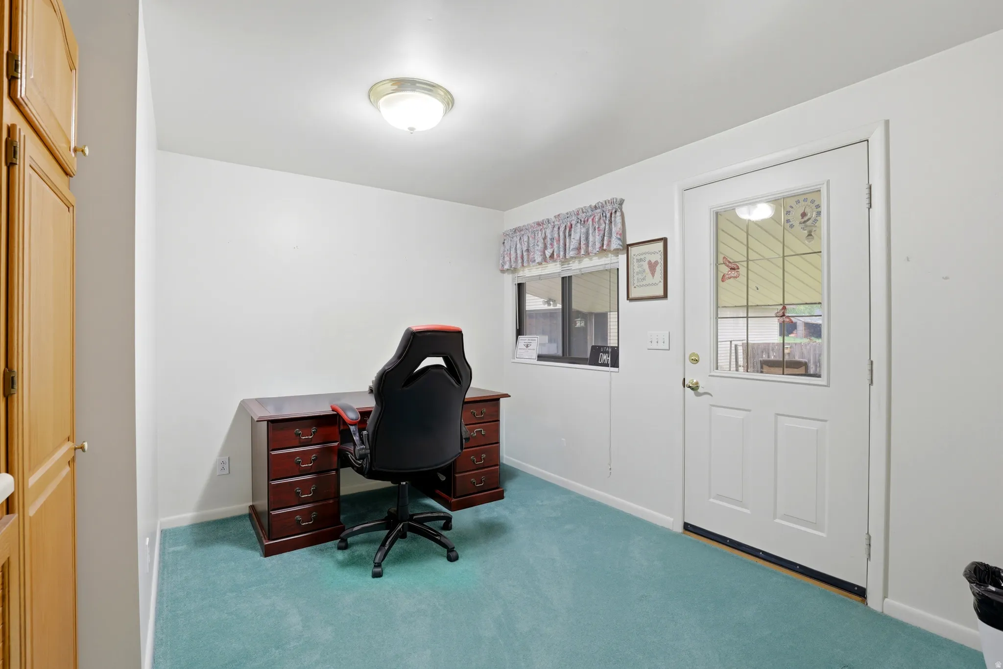 Carpeted home office featuring baseboards