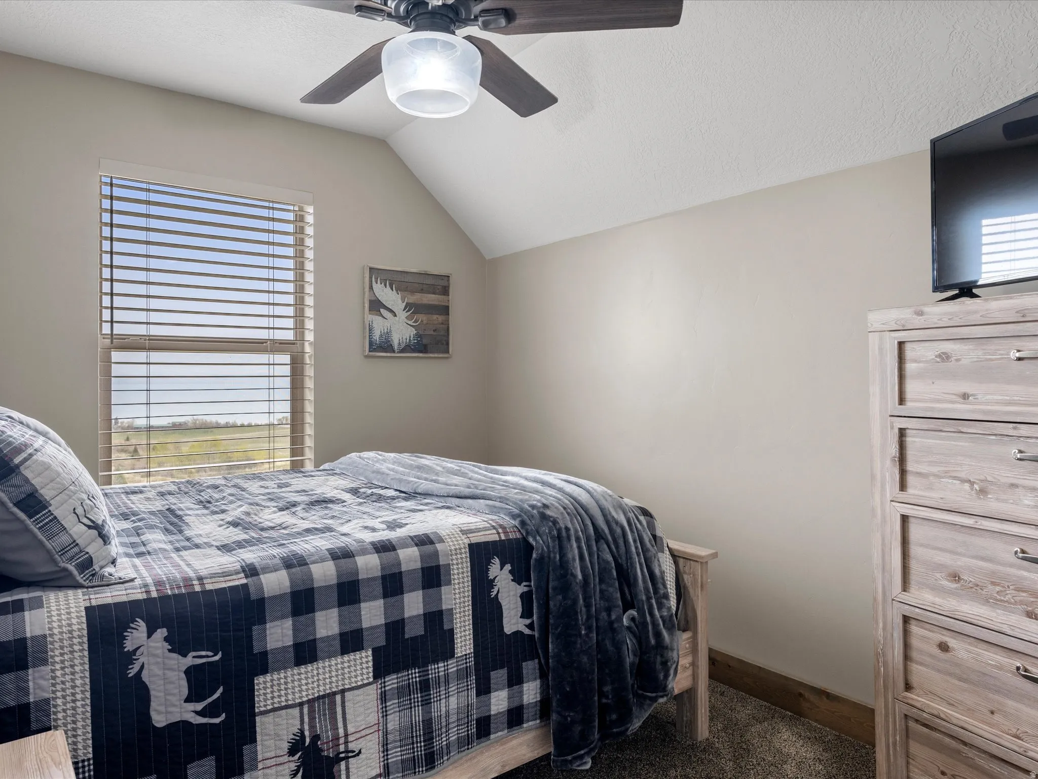 Bedroom featuring ceiling fan and dark colored carpet